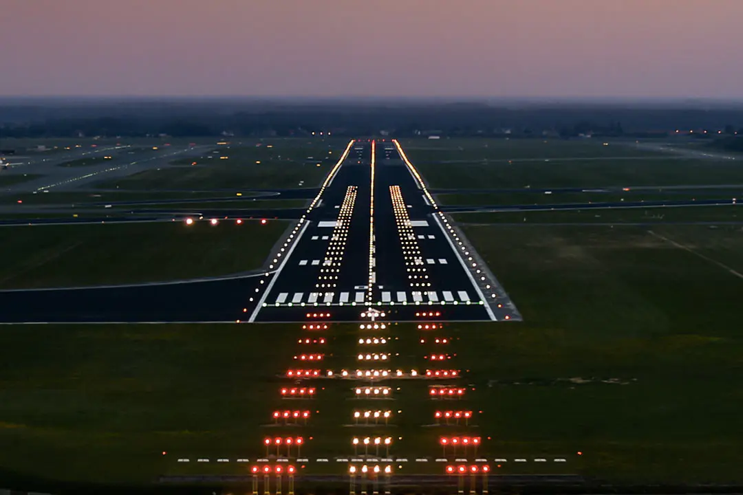 Airport runway at dusk with illuminated light - Runway Lights Explained | Colors, Spacing, Types - Vorlane