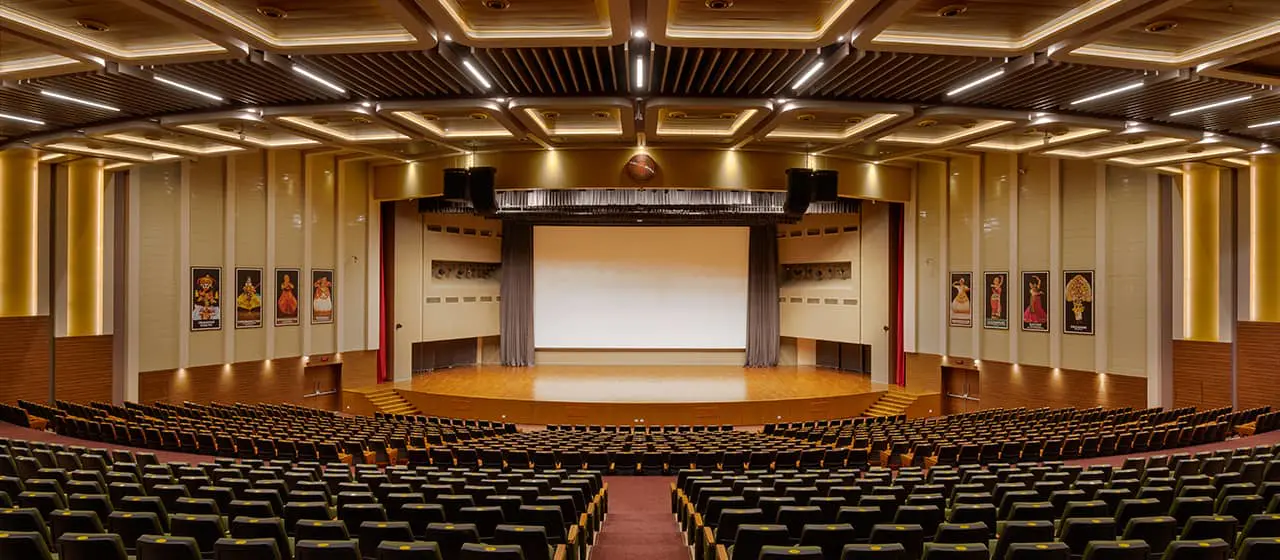 An auditorium with rows of chairs and a stage featured in the Guide to Auditorium Lighting - The Ultimate Guide to Auditorium Lighting - Vorlane