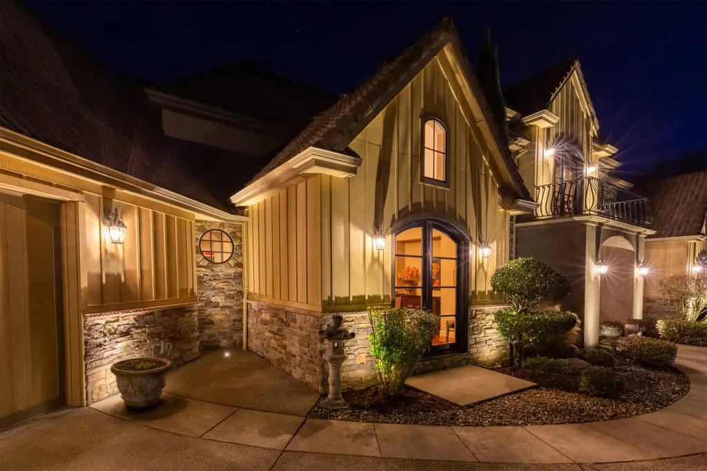 An elegant house at night illuminated by well placed exterior lights highlighting architectural details and landscaping - Enhance Your Home with Effective Front of House Lighting Positions - Vorlane
