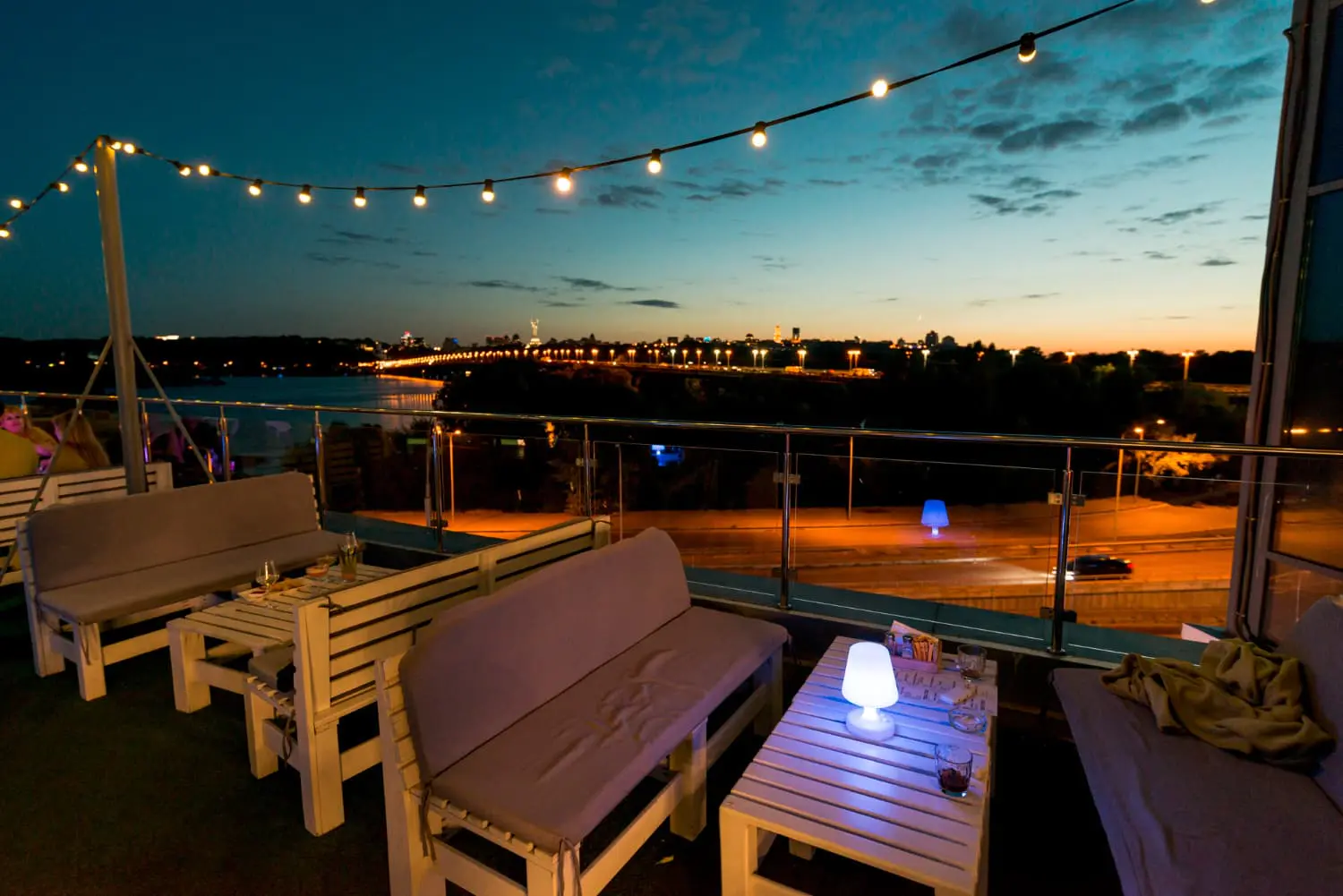 City skyline at night with patio and lights illuminated by dusk to dawn outdoor lighting - What is dusk-to-dawn outdoor lighting? - Vorlane