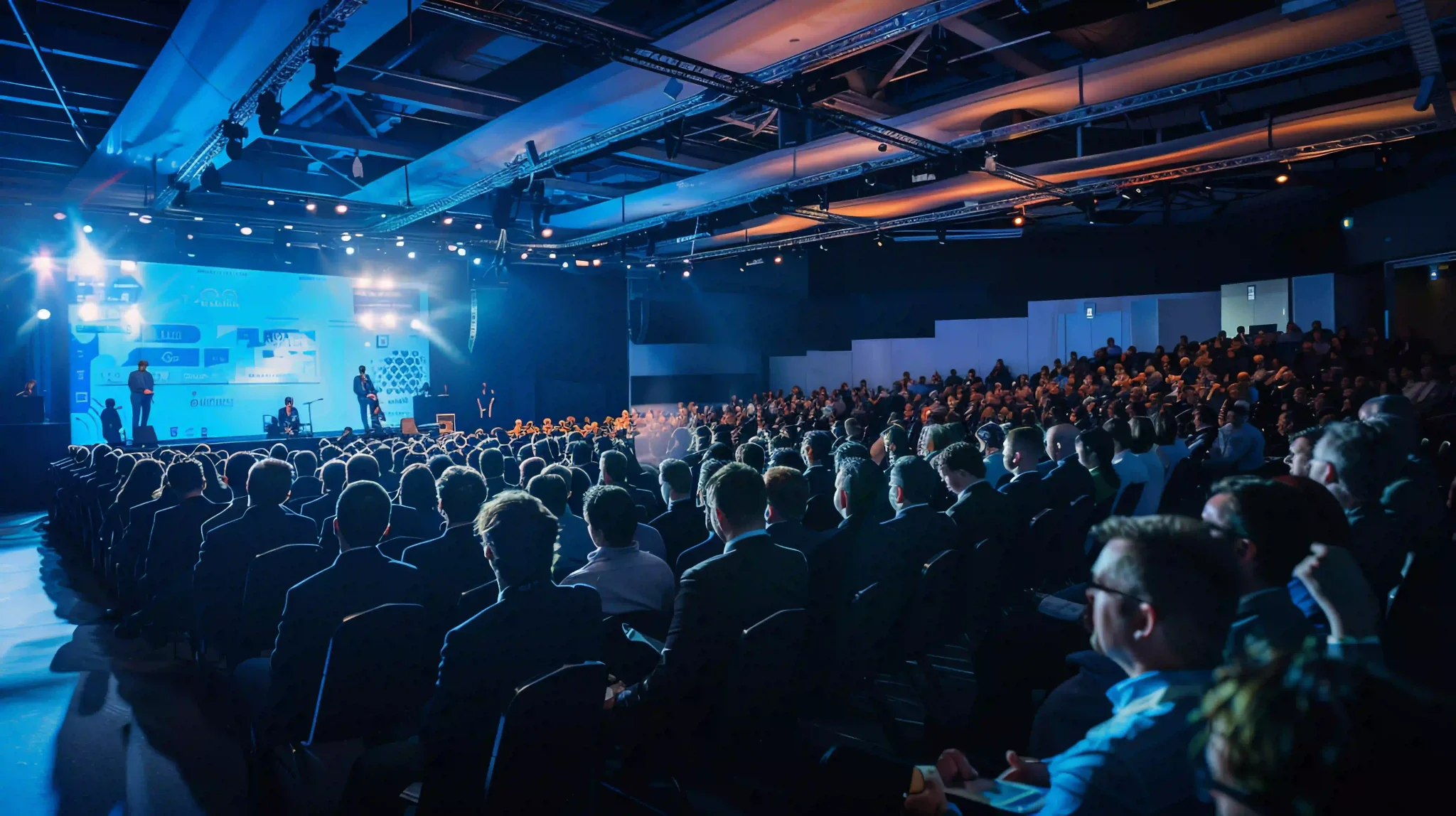 Engaged Audience at Business Conference with Impressive Lighting and Stage Setup