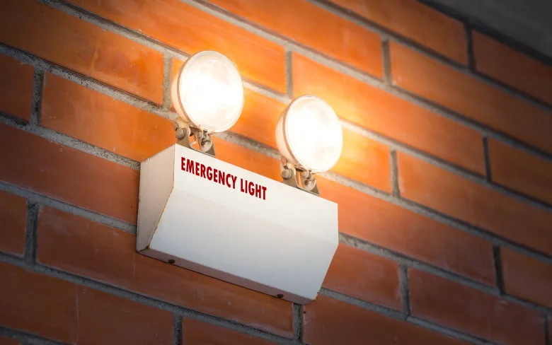 Illuminated brick wall with two lights white light glowing Picture included in A Guide to Emergency Lighting - A Guide to Emergency Lighting - Vorlane